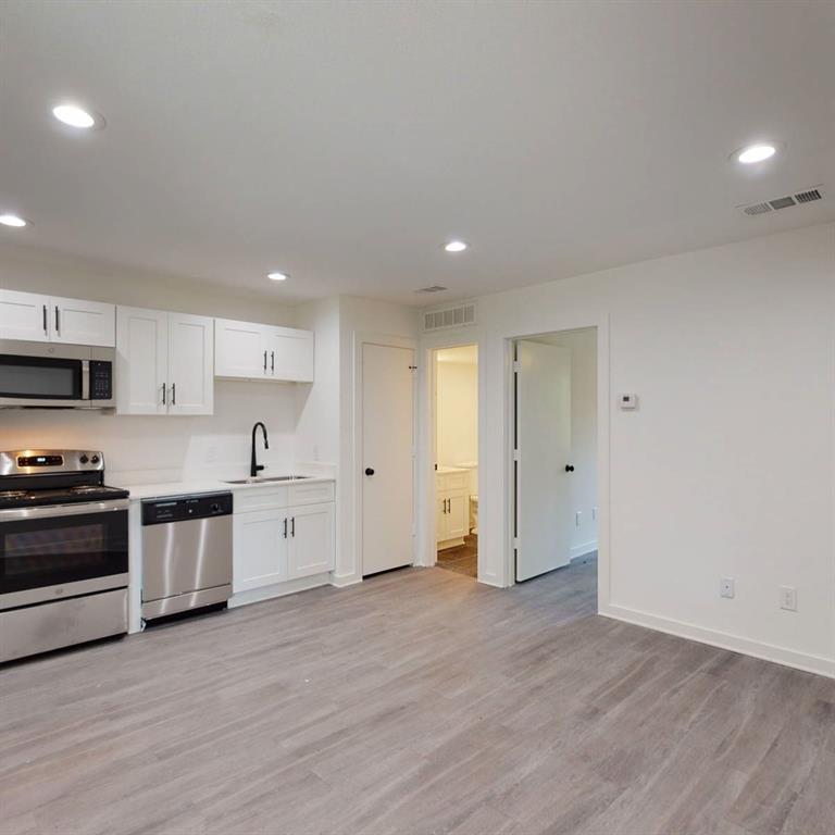 321 East 8th Street, Unit A2 Dallas, TX 75203 - Photo 12 of 14 a large kitchen with stainless steel appliances granite countertop a stove a sink and a refrigerator
