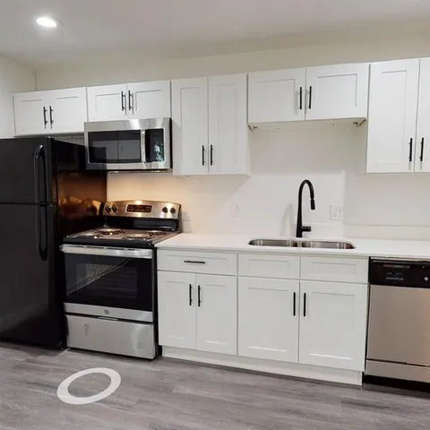 a kitchen with cabinets stainless steel appliances and a sink