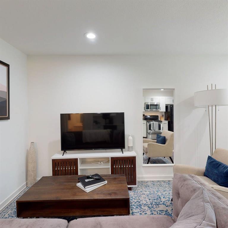 321 East 8th Street, Unit A2 Dallas, TX 75203 - Photo 4 of 14 a living room with furniture and a flat screen tv