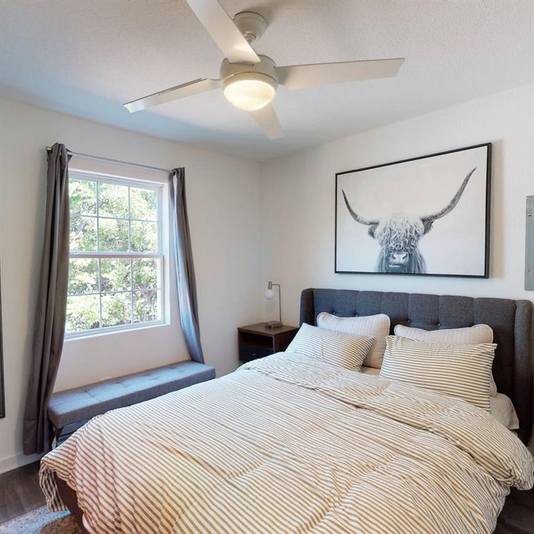 321 East 8th Street, Unit A2 Dallas, TX 75203 - Photo 6 of 14 a bedroom with a bed and a painting on the wall