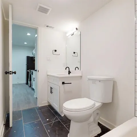 a bathroom with a toilet a sink and mirror