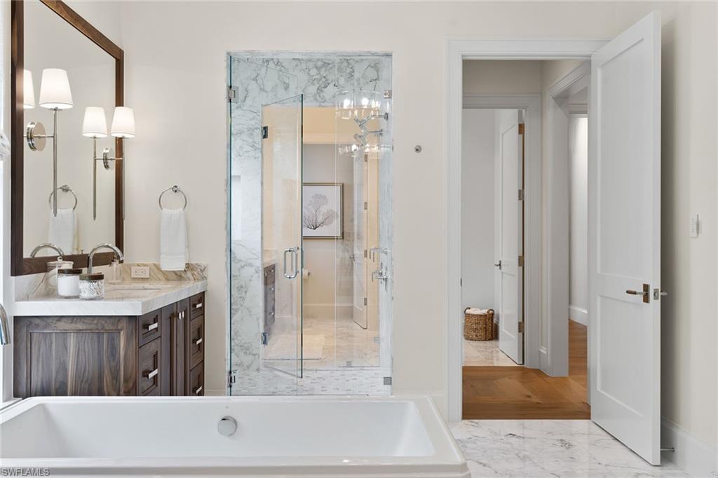 12 Sabre Lane Naples, FL 34102 - Photo 13 of 50 a bathroom with a granite countertop sink a mirror and a bathtub