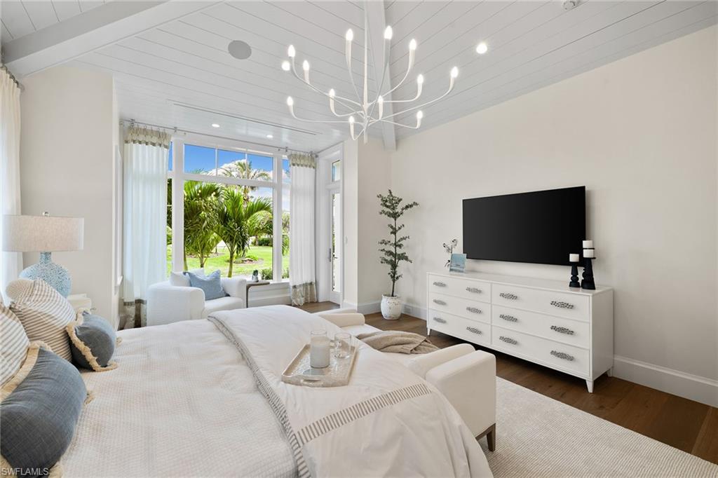 12 Sabre Lane Naples, FL 34102 - Photo 18 of 50 a bedroom with a bed tv and a large window