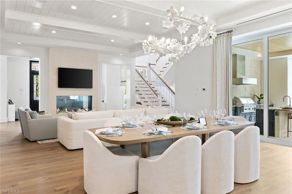 12 Sabre Lane Naples, FL 34102 - Photo 24 of 50 a living room with furniture a chandelier and a flat screen tv