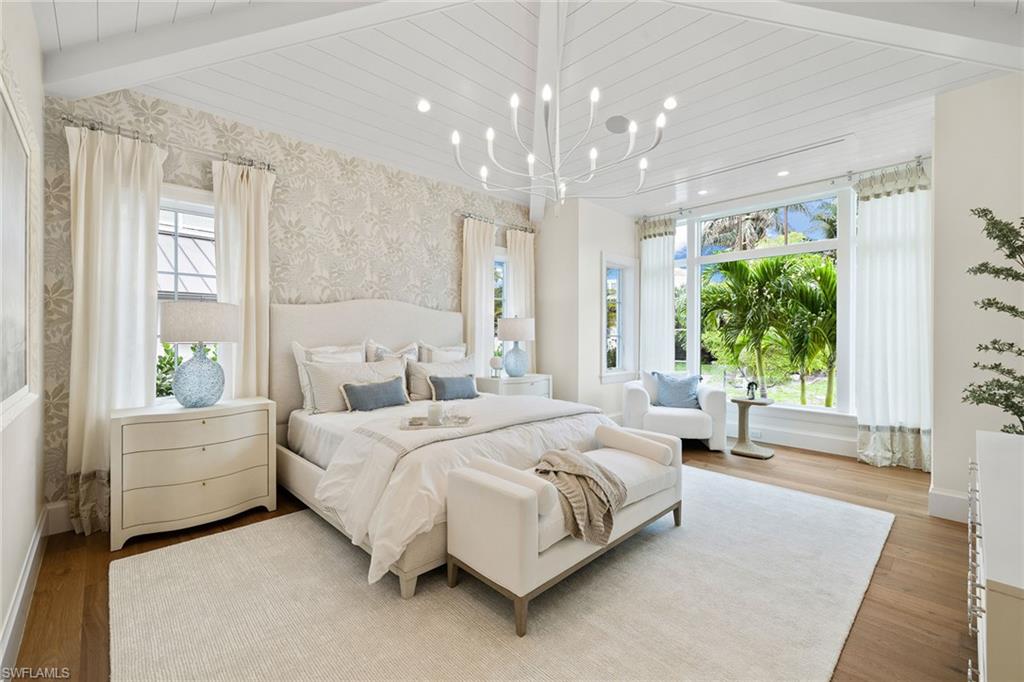 12 Sabre Lane Naples, FL 34102 - Photo 44 of 50 a bedroom with a large bed and a chandelier