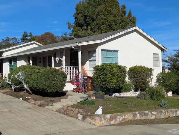 a view of a house with a yard and potted plants