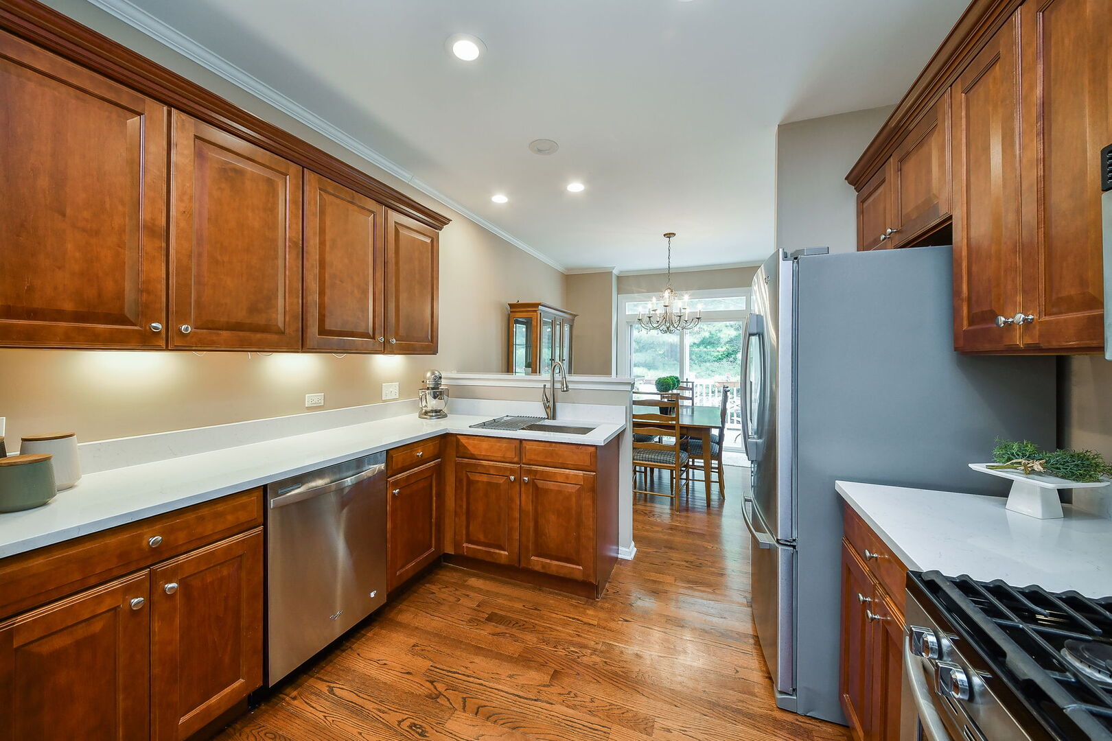 375 Ridge Road North Aurora, IL 60542 - Photo 7 of 24 a kitchen with stainless steel appliances granite countertop wooden cabinets a sink dishwasher a stove and a refrigerator with wooden floor