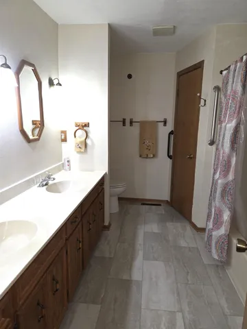 a bathroom with a double vanity sink mirror and toilet