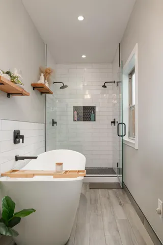 a bathroom with a tub a toilet and a shower