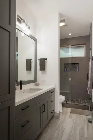 a bathroom with a double vanity sink mirror and shower