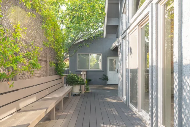 a balcony with wooden floor and outdoor seating