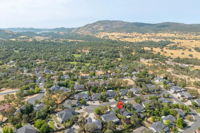 an aerial view of residential houses with outdoor space and trees