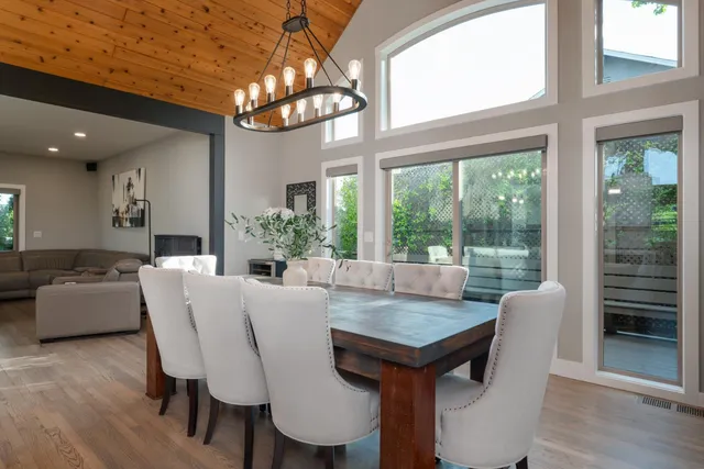a dining room with furniture a chandelier and wooden floor