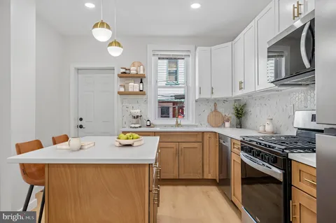 a kitchen with stainless steel appliances granite countertop a stove top oven a sink dishwasher and cabinets with wooden floor