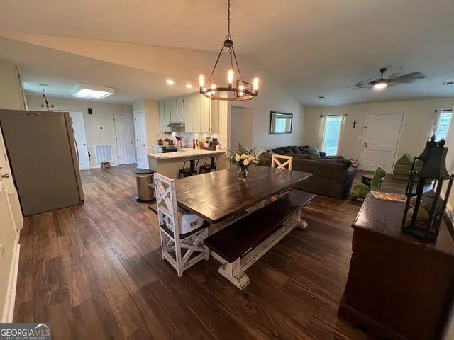 a living room with couches a dining table and chairs with wooden floor