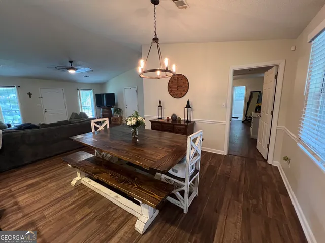 a living room with dining room and wooden floor