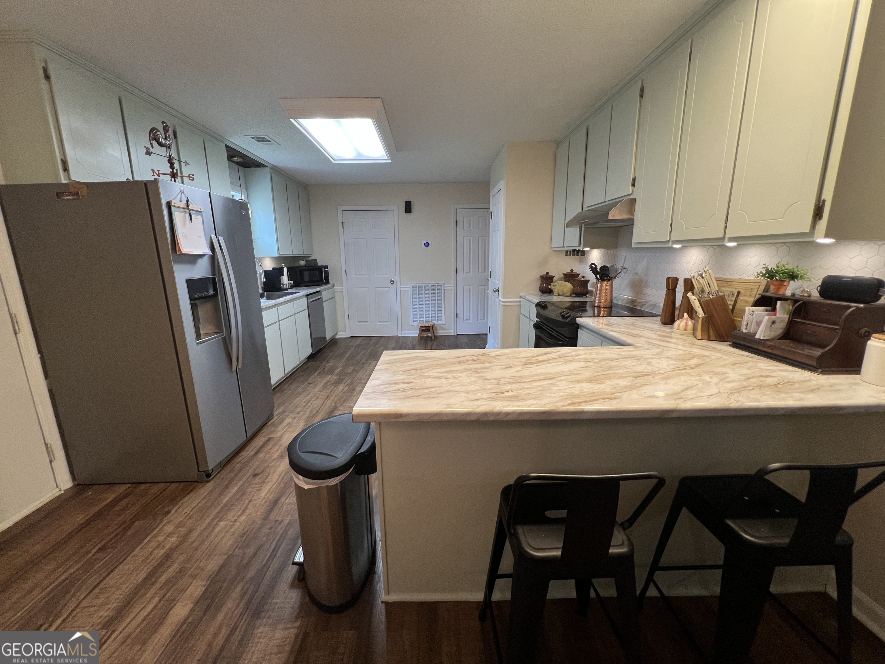 113 Camelot Drive Dublin, GA 31021 - Photo 16 of 45 a kitchen with stainless steel appliances kitchen island granite countertop a table chairs and a refrigerator