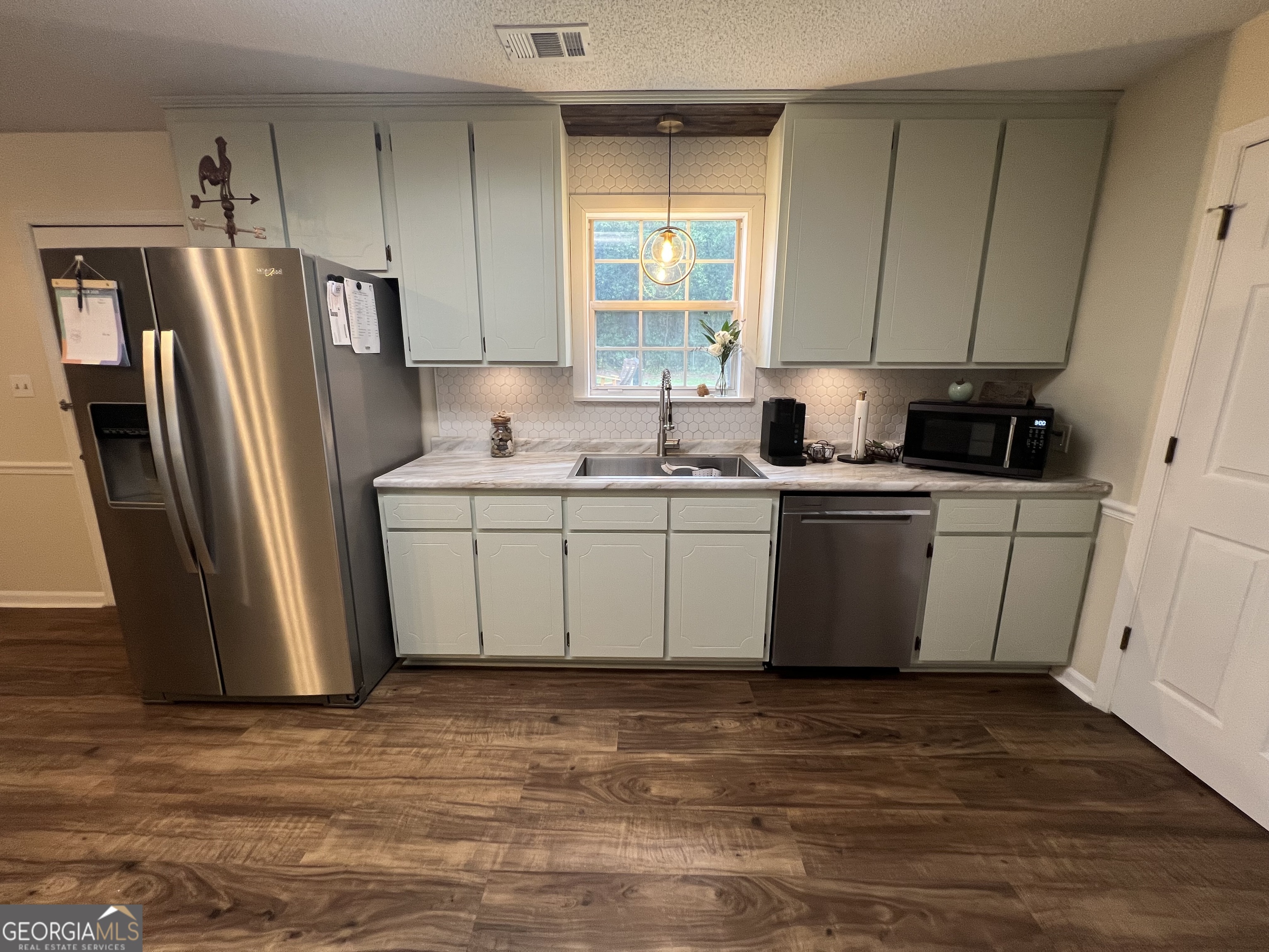 113 Camelot Drive Dublin, GA 31021 - Photo 19 of 45 a kitchen with stainless steel appliances a sink a refrigerator a window and a counter top space