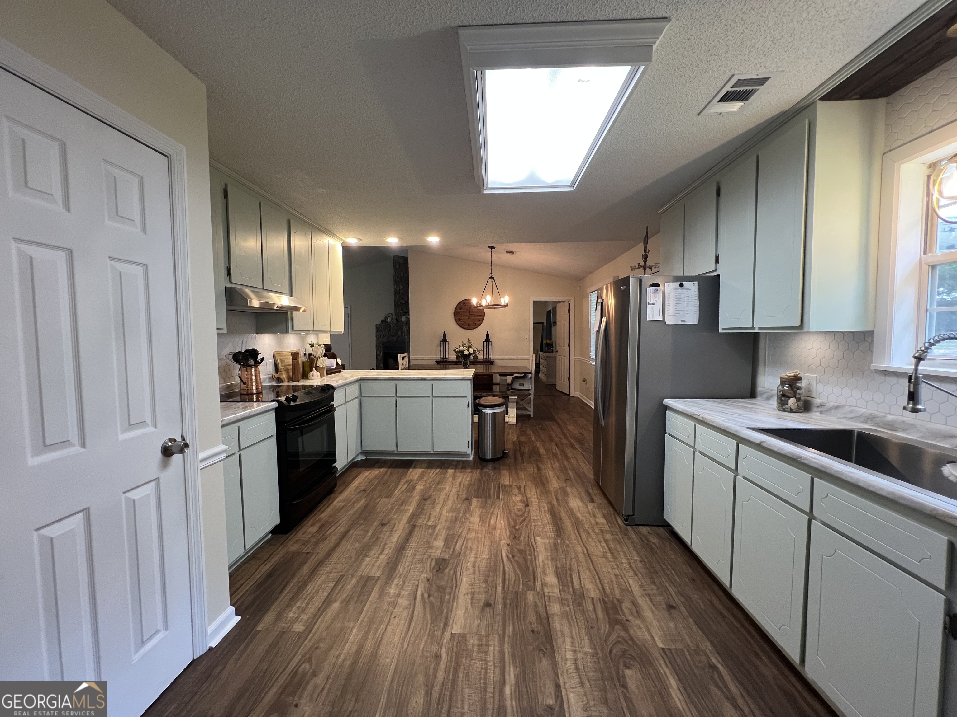 113 Camelot Drive Dublin, GA 31021 - Photo 20 of 45 a kitchen with a sink a refrigerator a counter top space and cabinets
