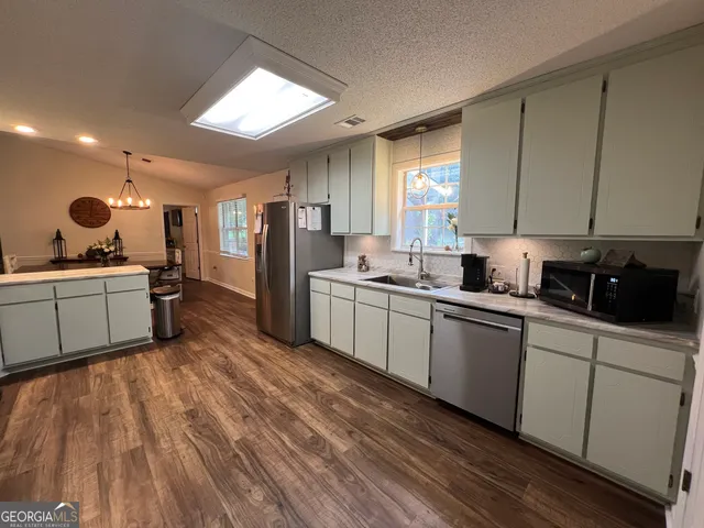 a kitchen with a sink stainless steel appliances and cabinets
