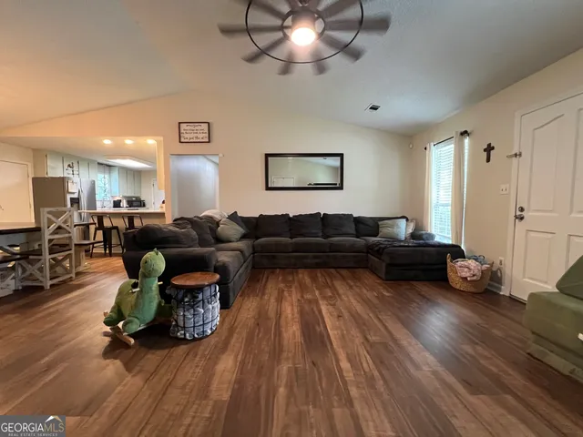 a living room with furniture and a wooden floor