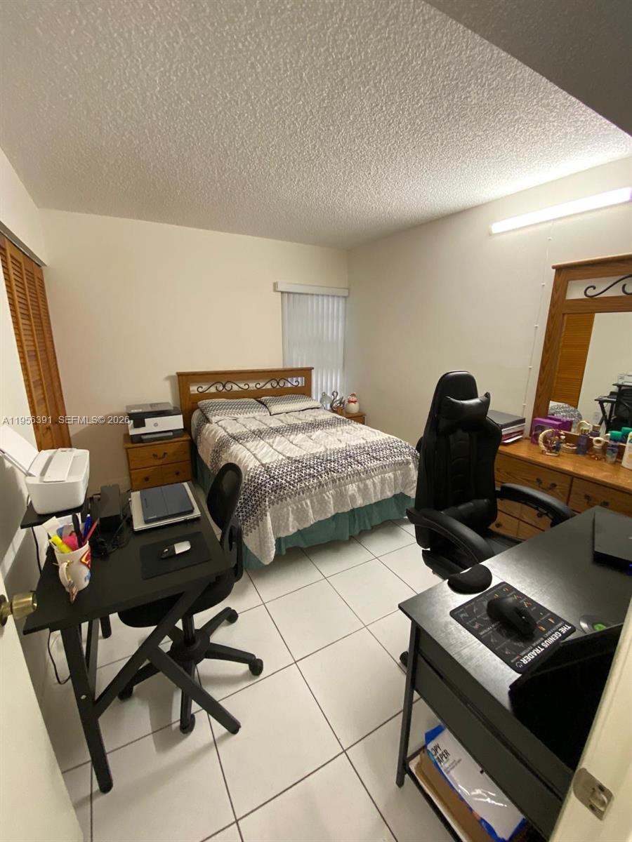 9070 Southwest 125th Avenue, Unit A101 Miami, FL 33186 - Photo 20 of 28 a bedroom with a workspace
