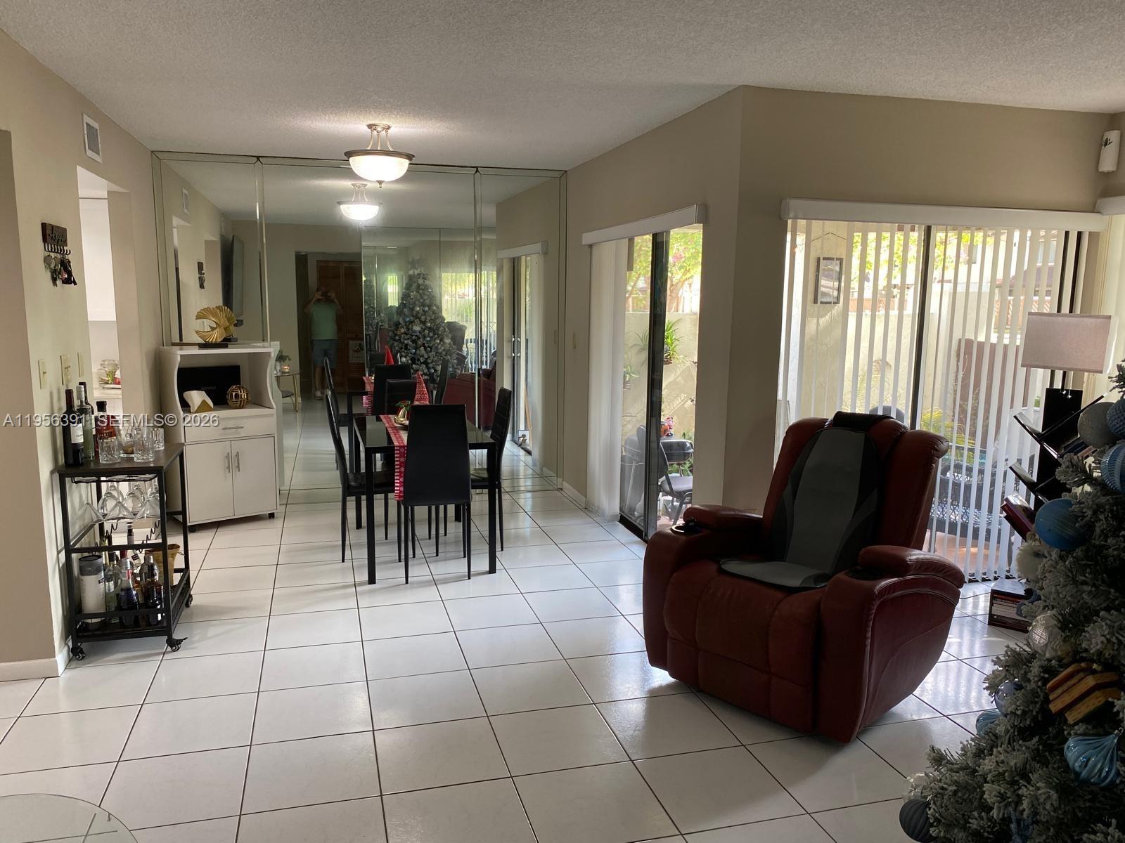 9070 Southwest 125th Avenue, Unit A101 Miami, FL 33186 - Photo 2 of 28 a living room with furniture and large windows