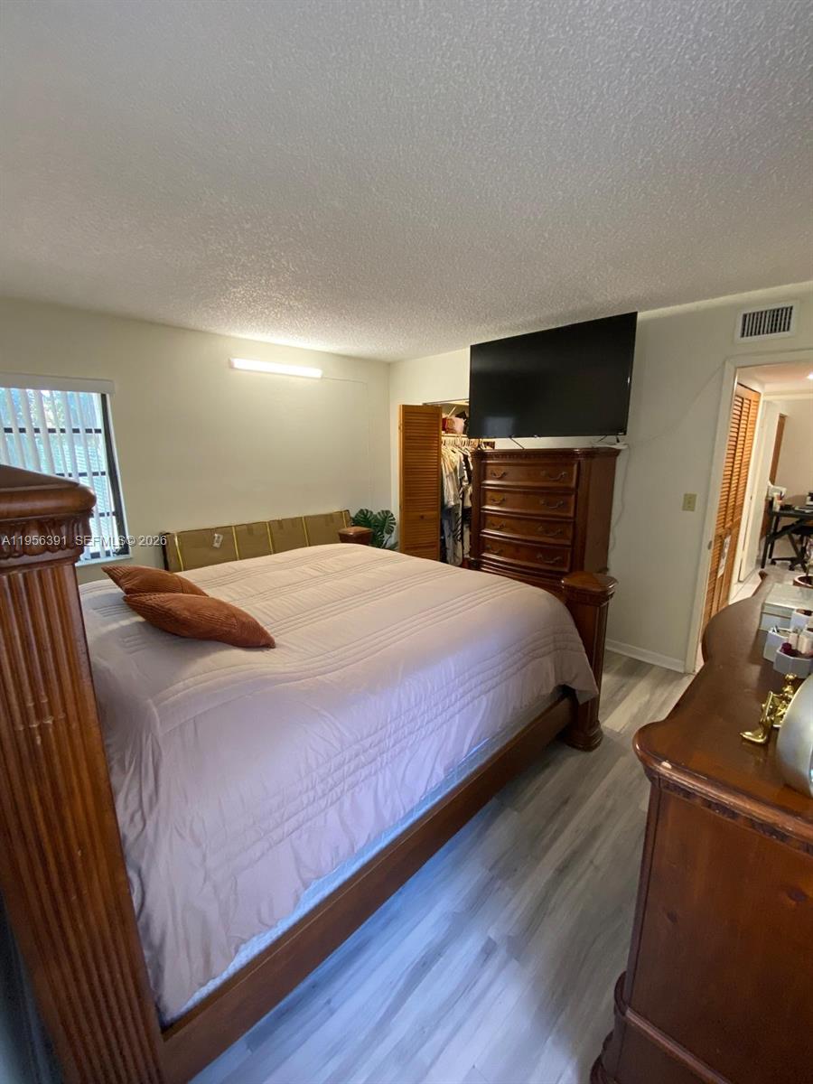 9070 Southwest 125th Avenue, Unit A101 Miami, FL 33186 - Photo 25 of 28 a bedroom with a bed a flat screen tv and dresser