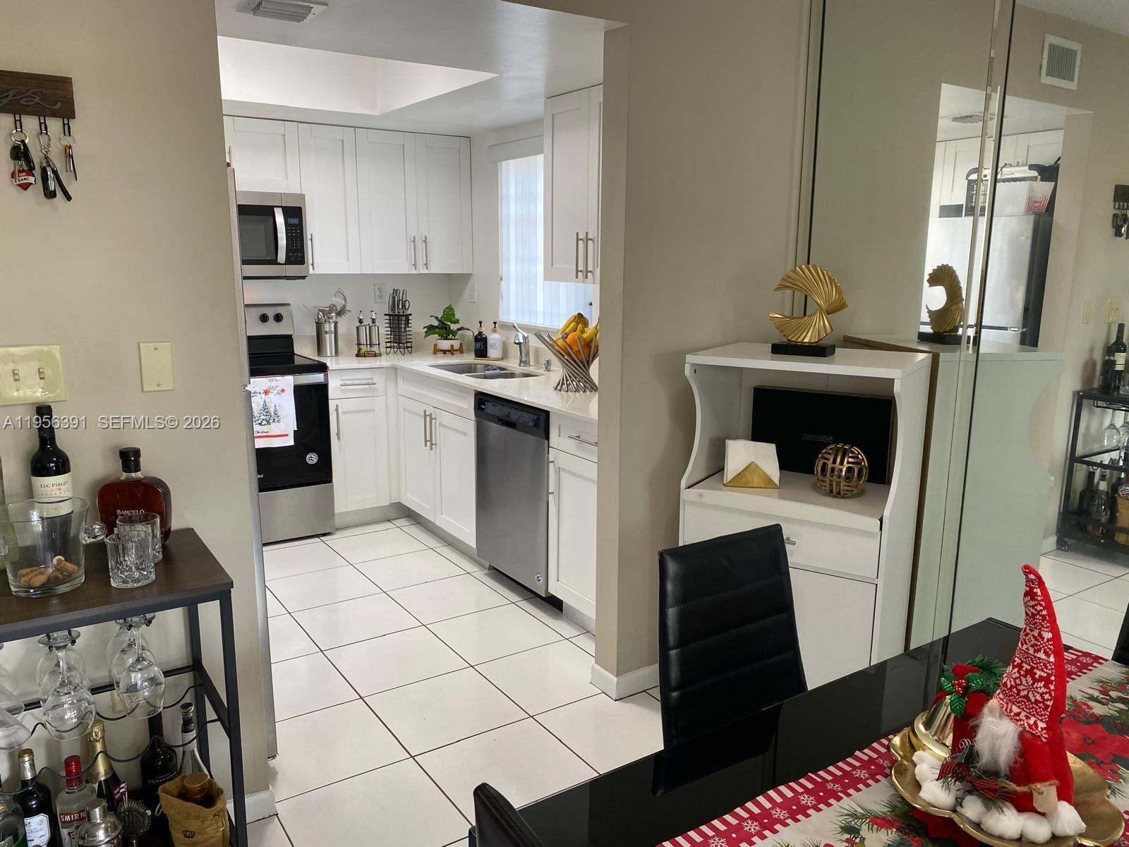 9070 Southwest 125th Avenue, Unit A101 Miami, FL 33186 - Photo 6 of 28 a kitchen with a refrigerator and cabinets
