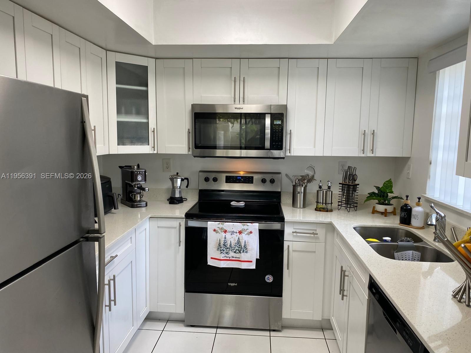 9070 Southwest 125th Avenue, Unit A101 Miami, FL 33186 - Photo 7 of 28 a kitchen with a refrigerator stove and microwave
