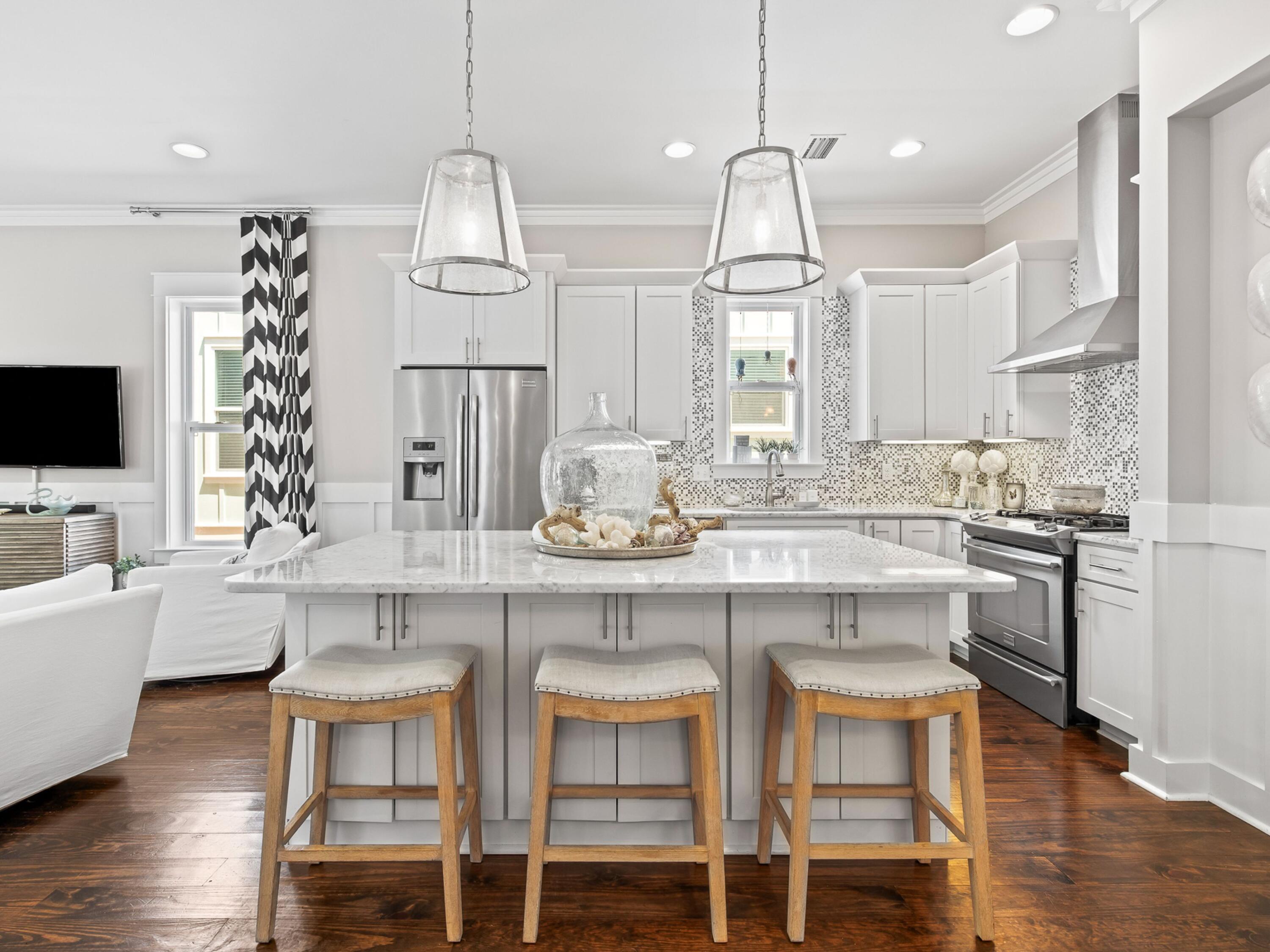 37 Dune Ridge Road Santa Rosa Beach, FL 32459 - Photo 11 of 40 a kitchen with kitchen island granite countertop a dining table chairs sink and white cabinets