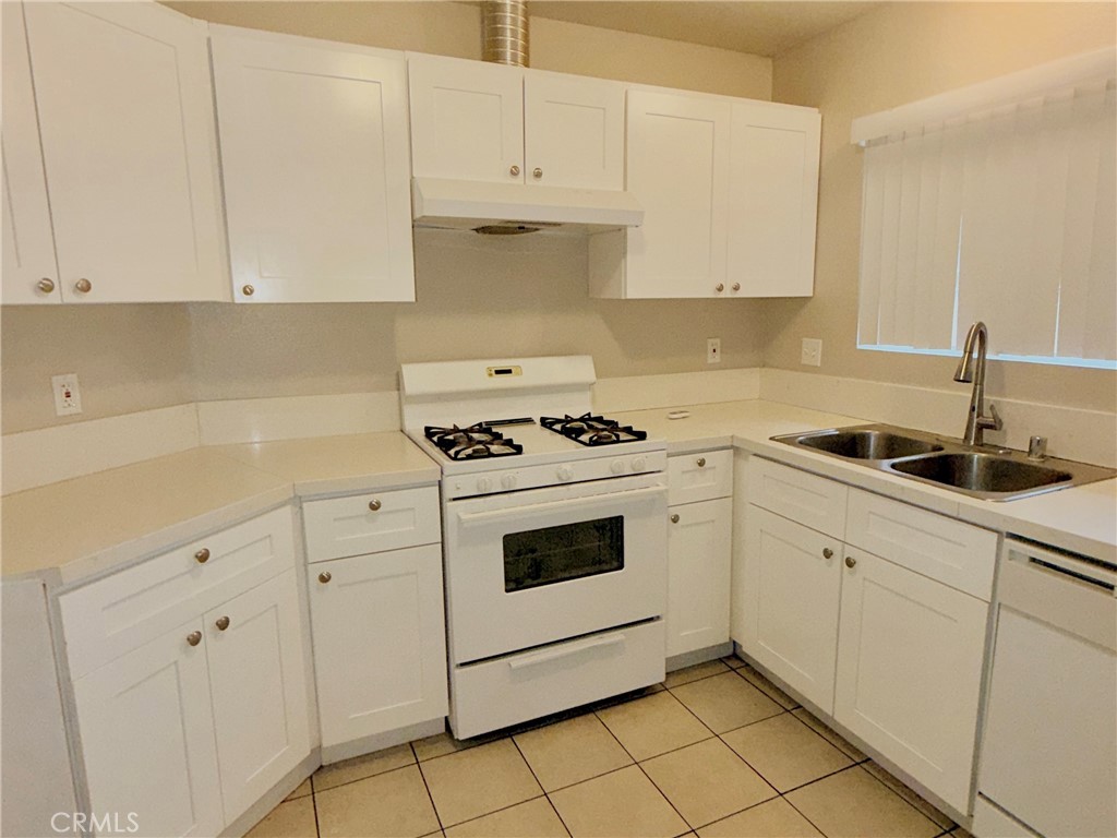a kitchen with granite countertop white cabinets and white appliances
