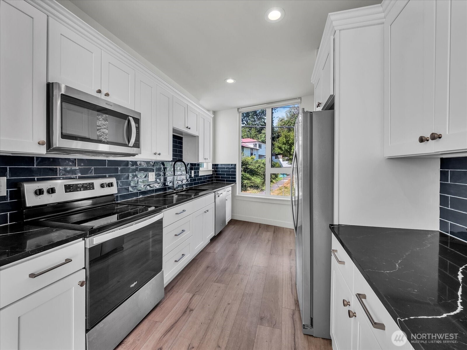 3628 14th Avenue South Seattle, WA 98144 - Photo 9 of 24 a large kitchen with stainless steel appliances granite countertop a stove a sink and a microwave