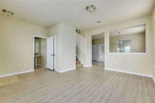 a view of a big room with wooden floor and windows