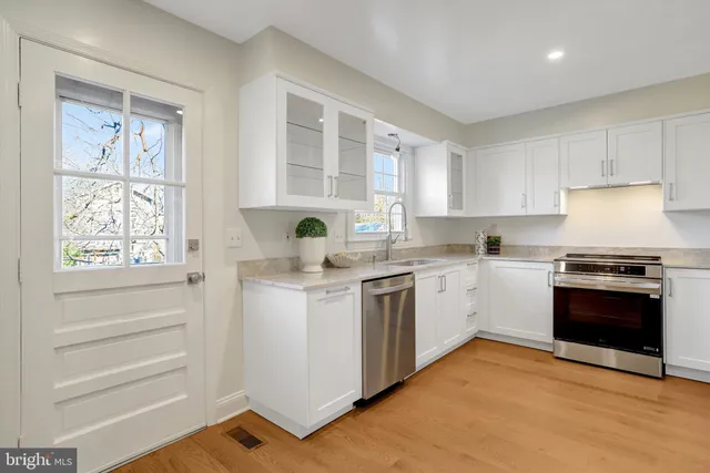 a kitchen with stainless steel appliances granite countertop a refrigerator stove and sink