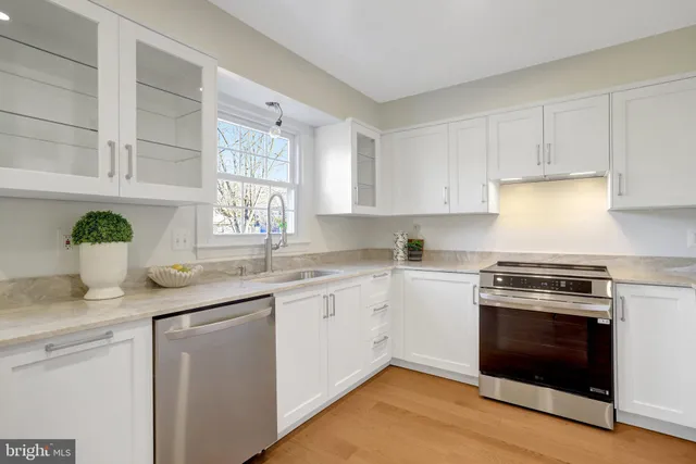 a kitchen with granite countertop white cabinets and white stainless steel appliances