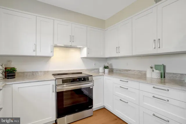 a kitchen with stainless steel appliances granite countertop a refrigerator a stove and a sink with granite countertops