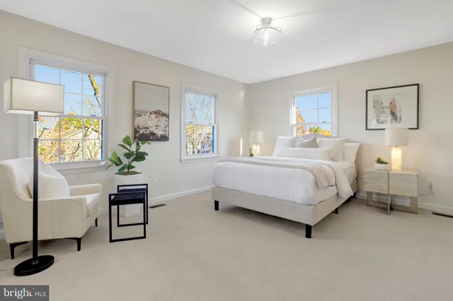 a bedroom with a bed a table and painting on the wall