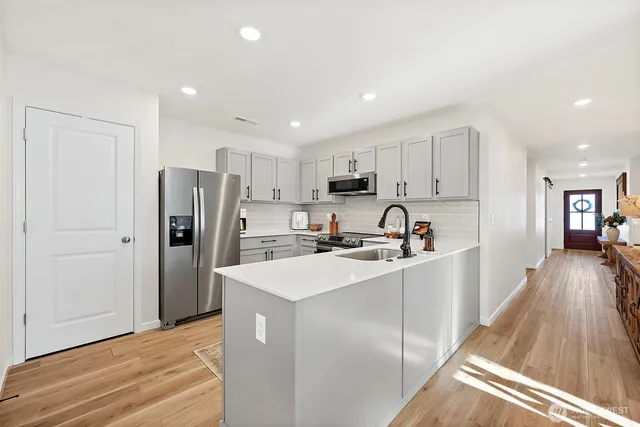 a kitchen with refrigerator cabinets and wooden floor