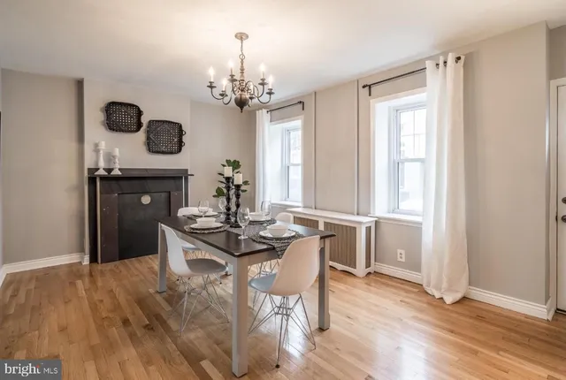 a view of a dining room with furniture a chandelier and wooden floor