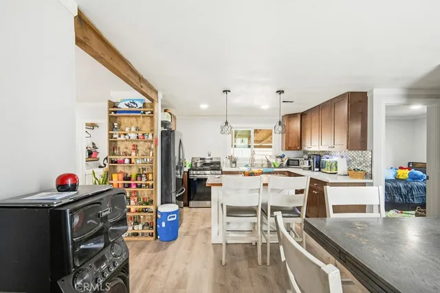 a kitchen with stainless steel appliances a table chairs refrigerator and sink
