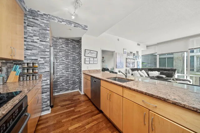 a kitchen with granite countertop kitchen island stainless steel appliances a stove sink and microwave