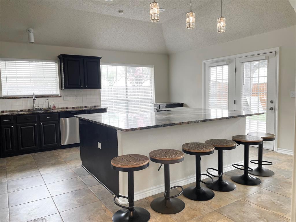 6404 Meadowview Court Plano, TX 75024 - Photo 12 of 33 a kitchen with granite countertop a sink and a refrigerator
