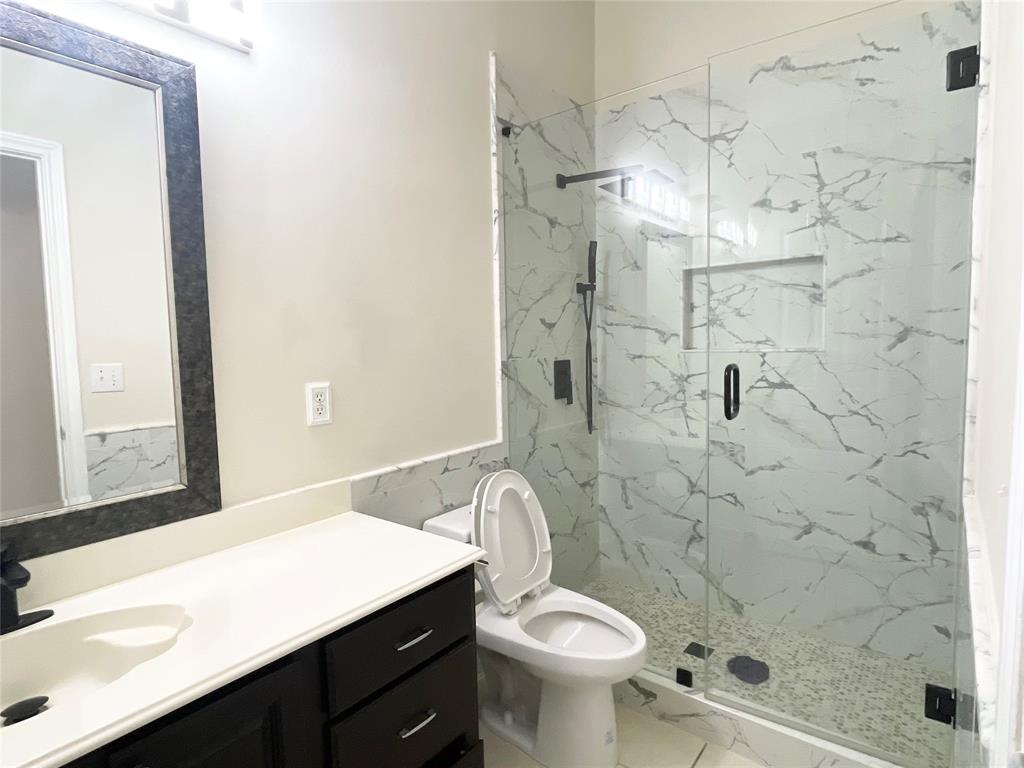 6404 Meadowview Court Plano, TX 75024 - Photo 18 of 33 a bathroom with a sink a toilet and shower
