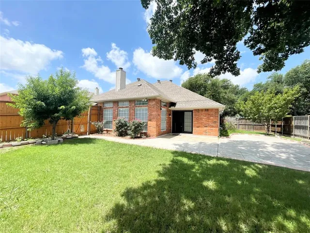 a front view of a house with a yard and trees