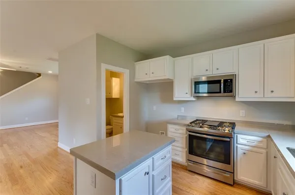 a kitchen with granite countertop white cabinets and white appliances
