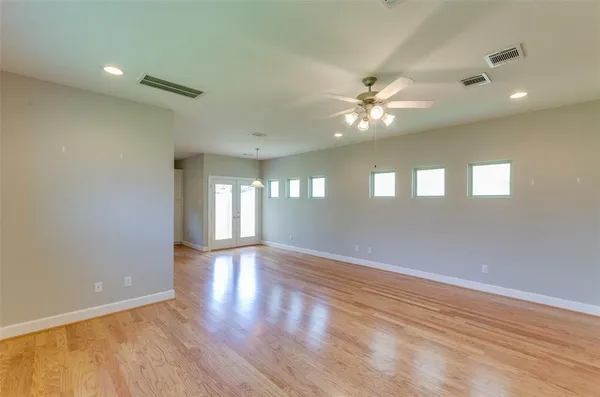 a view of an empty room with window and wooden floor