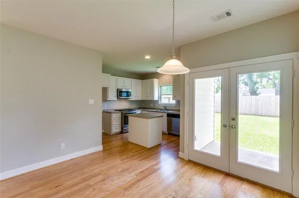 a kitchen with a stove a refrigerator and a wooden floor