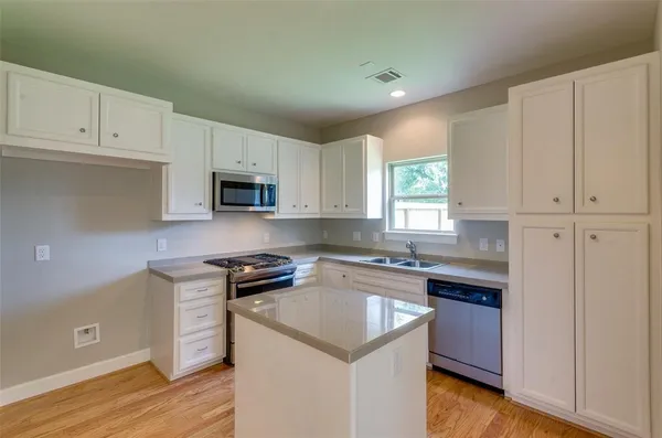 a kitchen with granite countertop a stove and a sink