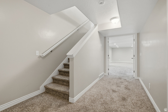 1997 East 600 South Springville, UT 84663 - Photo 34 of 54 Carpeted staircase with white handrail and trim, leading to a hallway with recessed lighting and a neutral color palette